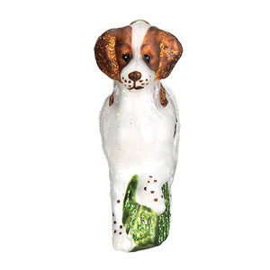 A glass brittany spaniel ornament featuring a white and brown spaniel with floppy ears and green glittery paws