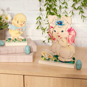 Vintage-style Easter decorations featuring a yellow chick and white bunny with blue and pink accents.