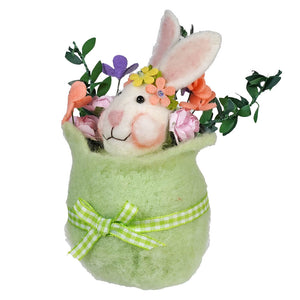White bunny in a mint green plush container decorated with flowers and a checkered bow.