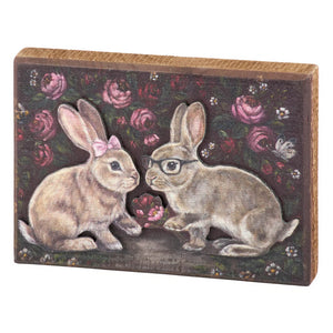 Rectangular wooden bunny love block sign with painted beige rabbits and dark rose background