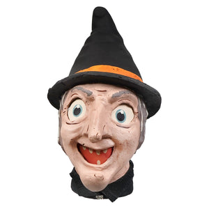 A cheerful painted cackling witch lantern with a black hat featuring an orange band and a wide toothy grin for honest heirloom decor