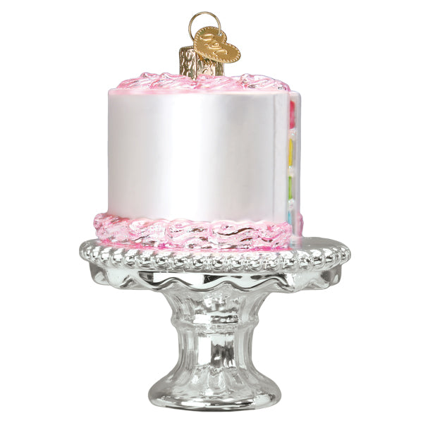 Delicate glass birthday cake ornament with silver frost pink icing and colorful layers on ornate silver stand
