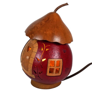 A hand-crafted lighted gourd shaped like a cozy red cottage with a brown roof by meadowbrooke gourds artisans