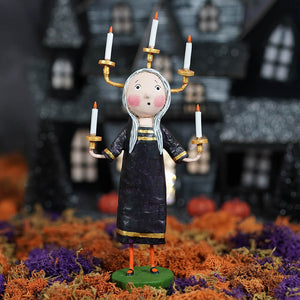 A whimsical black and gold lori mitchell halloween candle maker figure with long silver hair holding candlesticks
