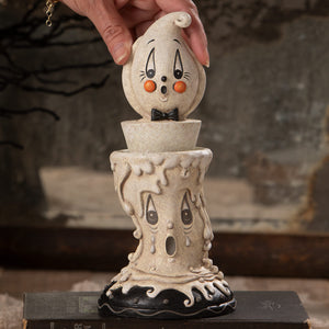 A whimsical cream ceramic candlestick ghost with orange cheeks and black bow tie perfect for johanna parker halloween decor