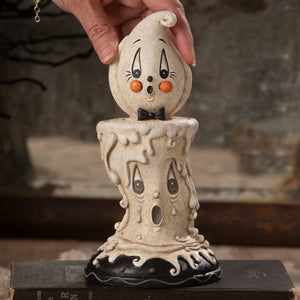 A cream-colored ceramic ghost candlestick with orange cheeks and bow tie perfect for johanna parker halloween decor
