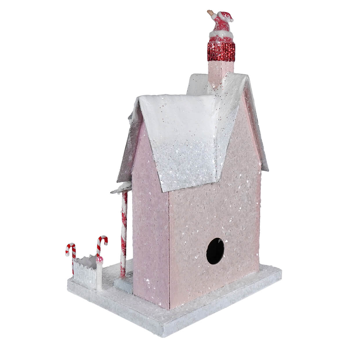 A festive pink glittery candy cane cottage house with snowy roof candy cane pillars and santa figurine spreading holiday cheer
