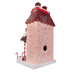 A festive pink glittery candy cane manor birdhouse with red sparkly roof and snow-dusted candy cane accents by cody foster
