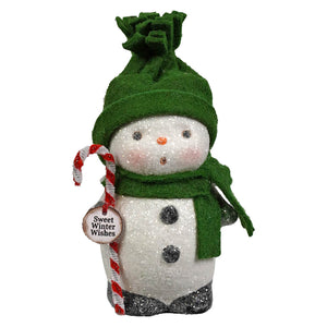 A glittery white snowboy figurine by bethany lowe designs wearing a green knit hat and scarf holding a candy cane