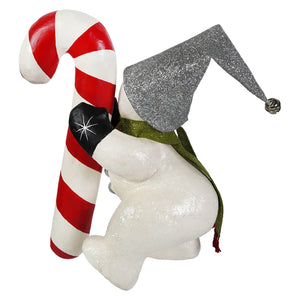 A festive white christmas snowman figure wearing a glittery silver jester hat and holding a red and white candy cane decor
