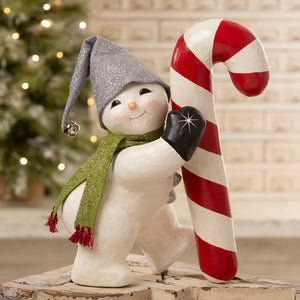 A charming white christmas snowman figure wearing a glittery gray hat and green scarf holding a red and white candy cane