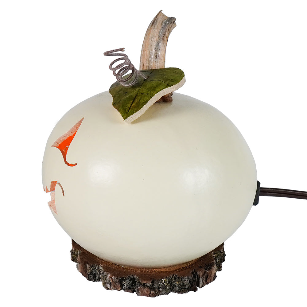 Cream-colored cannon lighted jack-o-lantern gourd with orange face green stem on wood base by meadowbrooke gourds artisans