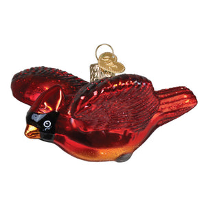 A glossy red glass miniature cardinal ornament with a black head, orange beak, and gold tipped wings figural decor