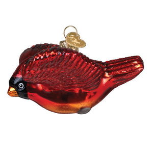 A glossy red glass cardinal ornament with black and orange accents and a gold heart tag perfect as figural decor