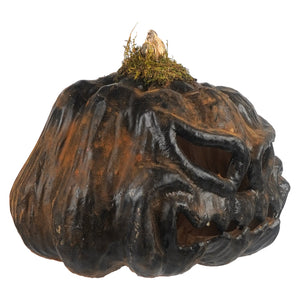 A rustic dark brown and black smiling carved pumpkin jack o lantern with mossy stem and tea light inside