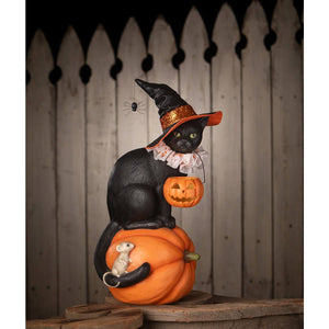 Black cat witch figurine sitting on an orange pumpkin perfect for halloween cats and witch decor