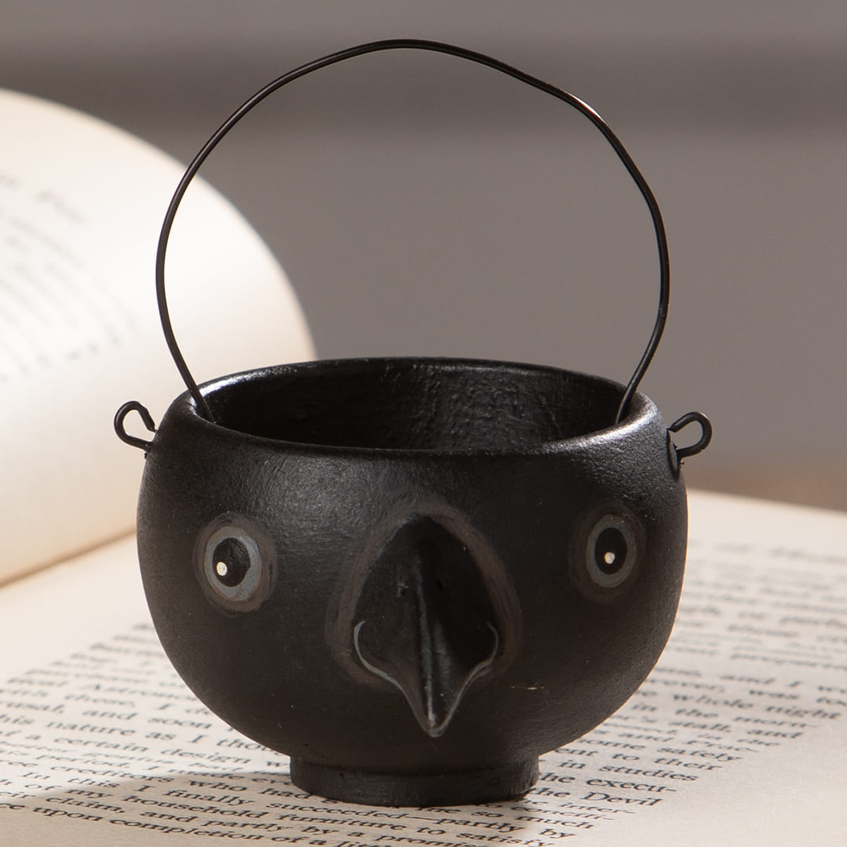 Black cast iron cauldron shaped bethany lowe halloween egg cup with googly eyes and wire handle called caw egg cup