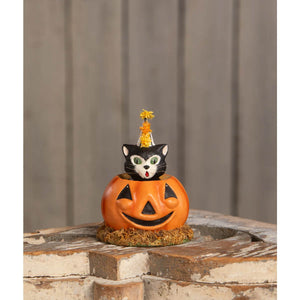 Orange pumpkin-shaped container from cecil’s hang with a black and white cat wearing a yellow party hat peeking out