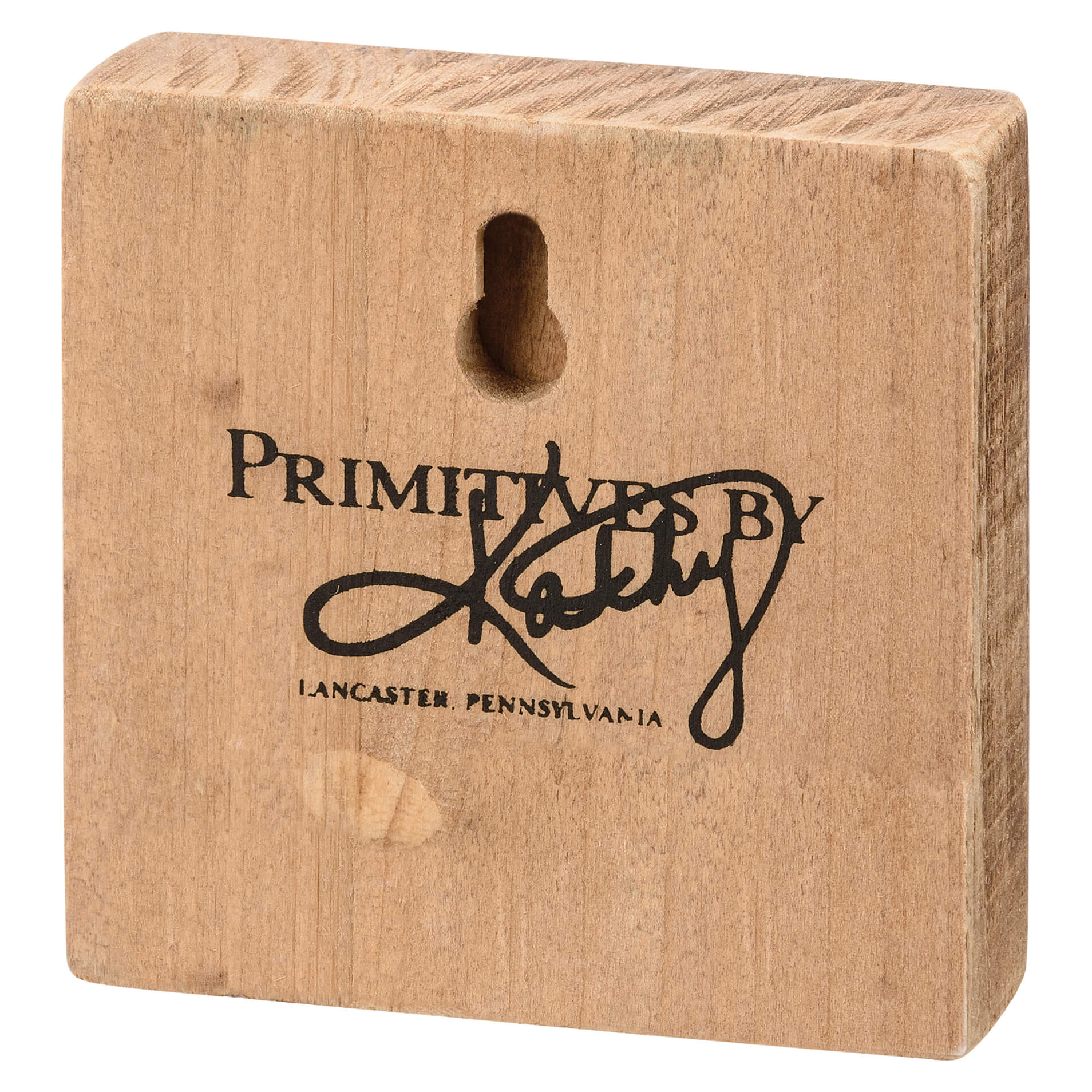 Wooden block with ’Primitives By’ branding from Lancaster, Pennsylvania engraved on its surface.