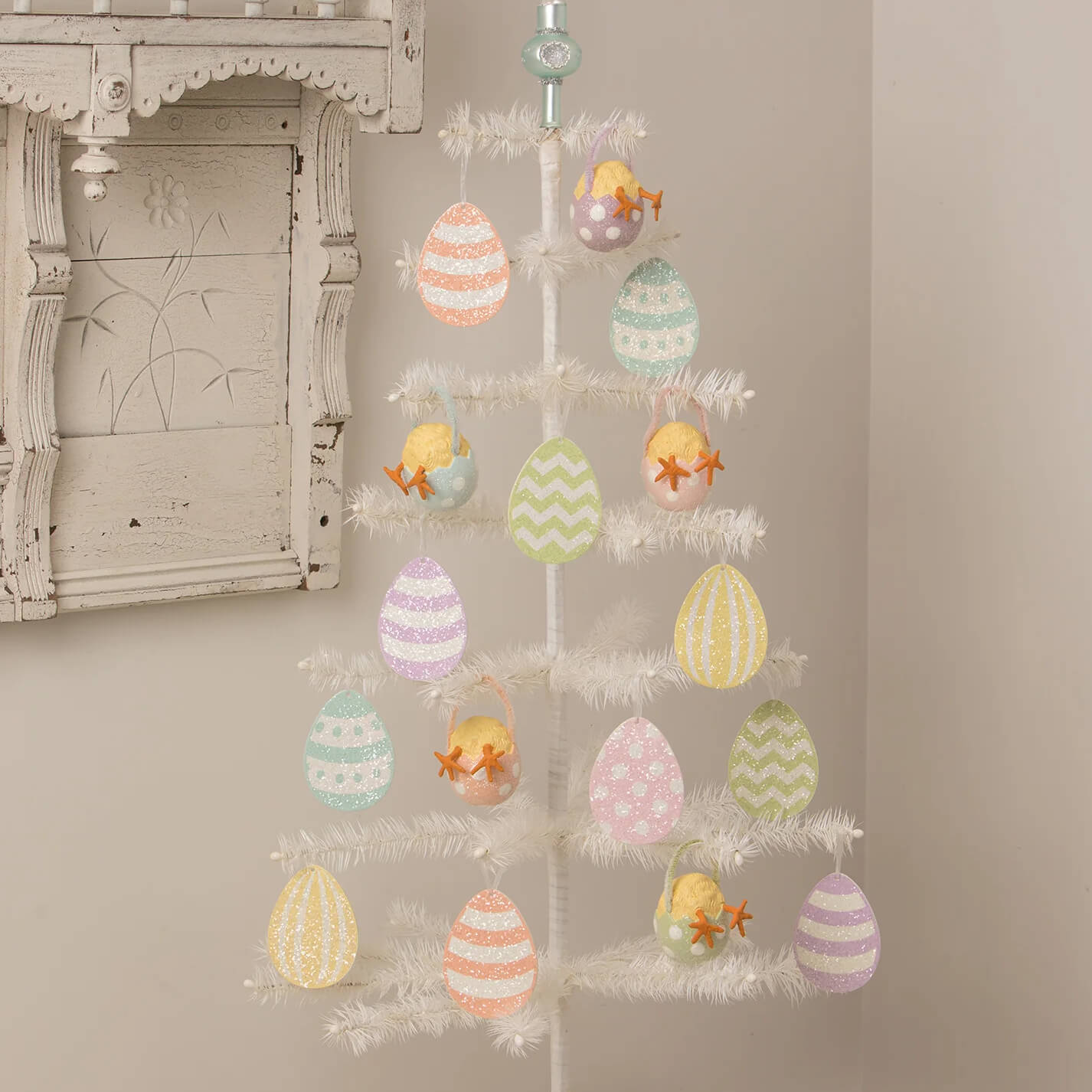 A white artificial christmas tree decorated with pastel bethany lowe chick tail ornament easter eggs and decorative grass