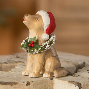 A tan resin bethany lowe design christmas caroling dog figurine wearing a santa hat and holly wreath collar