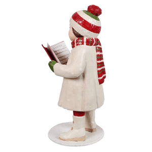 A christmas caroling leah figurine with red white and green knit hat scarf and cream coat for christmas tabletop decor