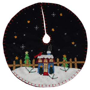 Black felt christmas tree skirt with red stitching featuring a cozy christmas house under stars and snowflakes design