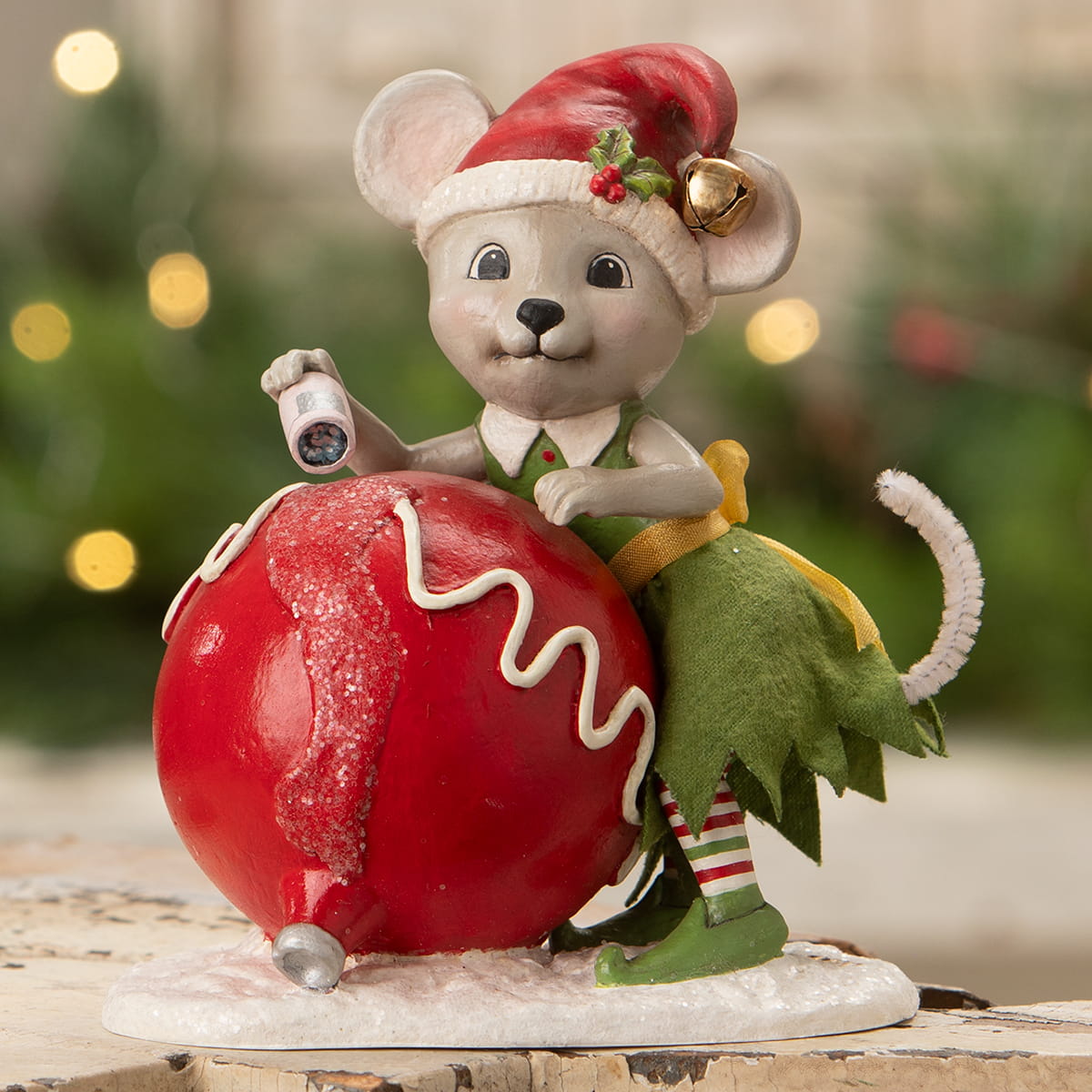 A bethany lowe design christmas mouse gidget figurine dressed as an elf on a red ornament with a flashlight