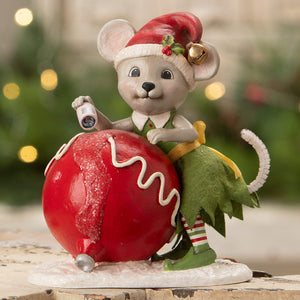 A bethany lowe design christmas mouse gidget figurine dressed as an elf on a red ornament with a flashlight