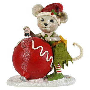 A bethany lowe design christmas mouse gidget figurine dressed as an elf holding a camera next to a red christmas ornament