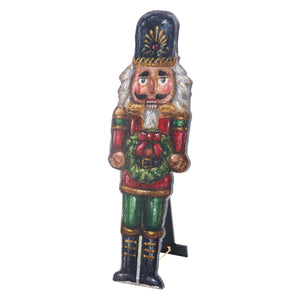 A festive wooden christmas nutcracker porch leaner in red and green with gold trim holding a wreath holiday statement piece