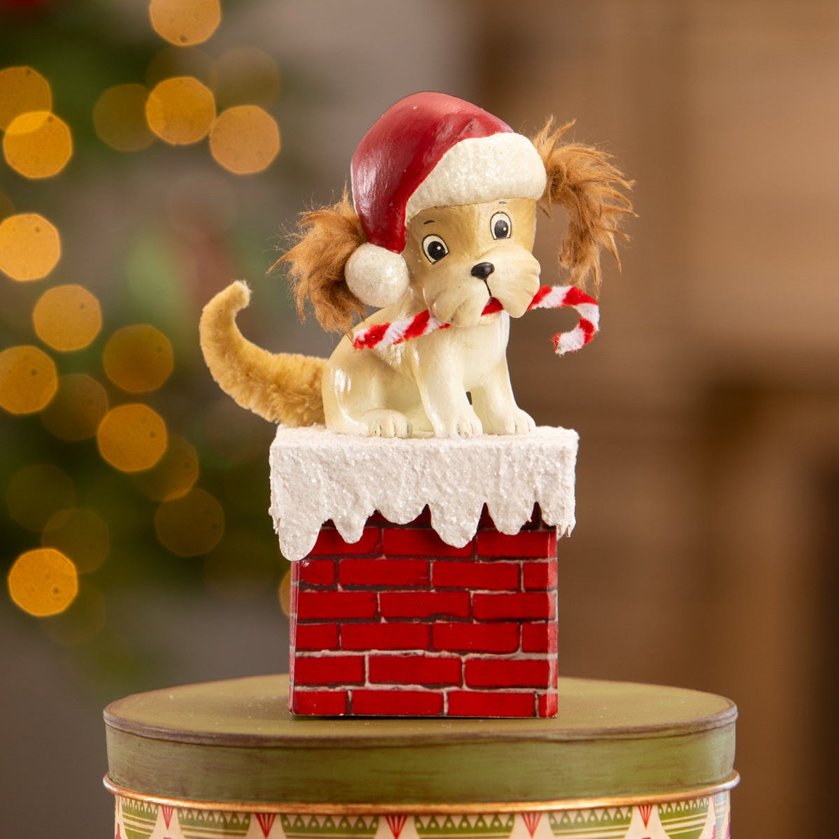 A charming cream christmas puppy ceramic figurine by bethany lowe designs in red santa hat on a red chimney box