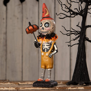 Circus skelly skeleton decor figure wearing red cone hat and orange overalls holding pumpkin on a stick