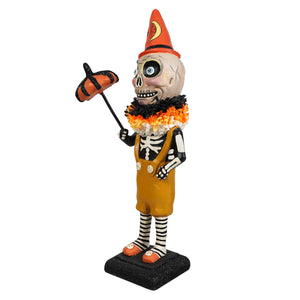 Circus skelly halloween-themed skeleton decor figure in orange overalls holding a pumpkin umbrella with striped socks