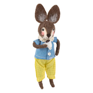 A charming brown felt coffee rabbit critter wearing a blue shirt and yellow pants holding a small white teacup