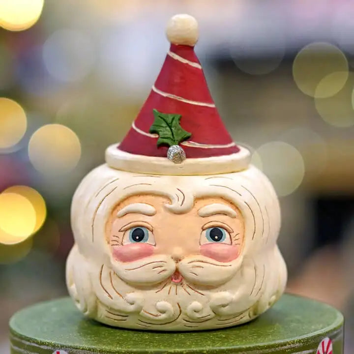 Decorative Santa Claus face figure with a red hat on a blurred festive background