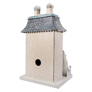 A charming white chateau house birdhouse with a gray snow-dusted roof and two chimneys for your christmas village