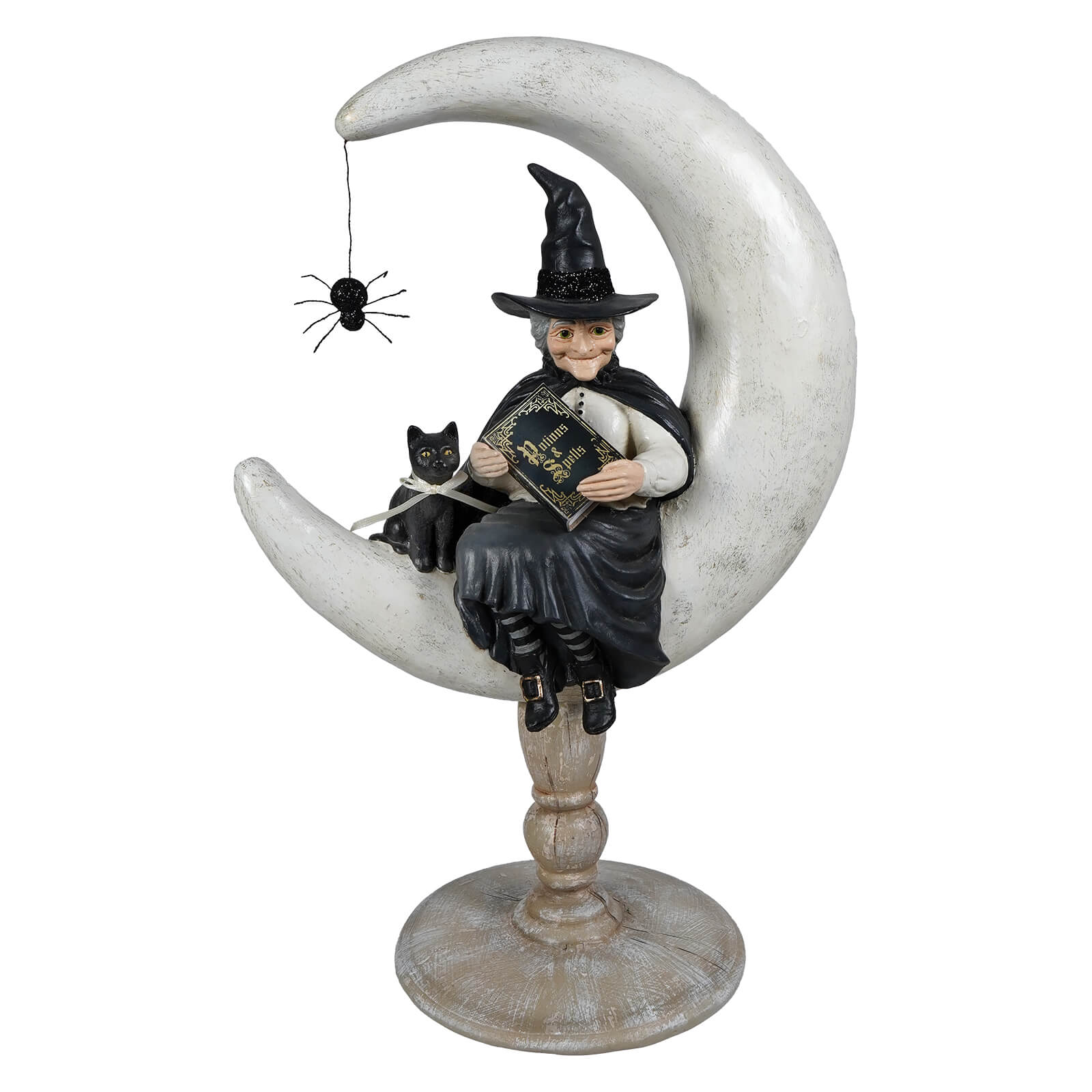 A whimsical moon moira witch figurine in black cloak on a weathered white crescent moon holding a gold detailed book