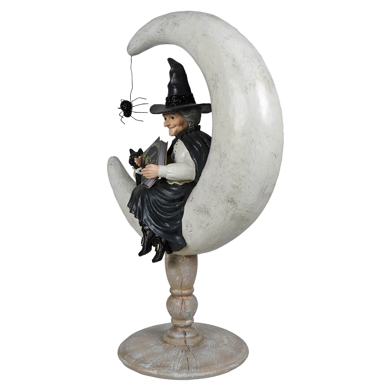 A whimsical crescent moon moira witch figurine dressed in black sitting on a weathered gray crescent moon base perfect for halloween witches decor