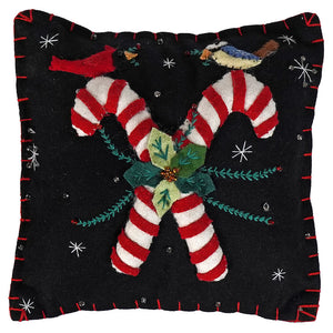 Black felt birds pillow with crossed canes, red and white stripes, green poinsettia, and silver stars holiday pillows