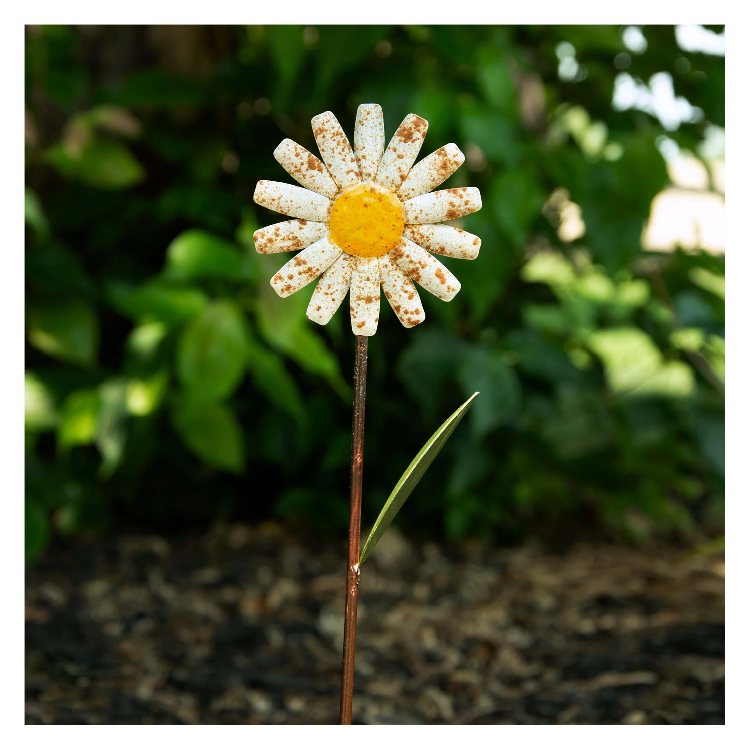 A rustic daisy garden pick with speckled white petals yellow center decor piece and copper-colored stem for garden use