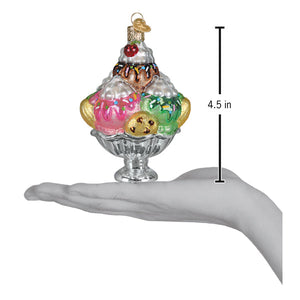 Colorful hand-blown glass decadence delight sundae ice cream ornament with pink green scoops chocolate drizzle and cherry on top