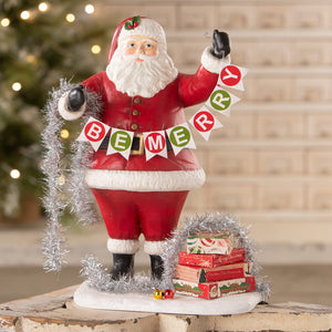 Deck the halls santa figurine by bethany lowe designs holding silver tinsel with be merry banner and gift boxes
