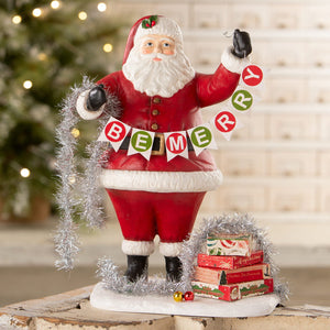 Deck the halls santa figurine by bethany lowe designs red and white folk art santa holding be merry banner with silver tinsel
