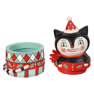 A black and white cat figurine with a red santa hat and scarf sits on a holiday pot in the dezzy merry boo gift box by bethany lowe designs