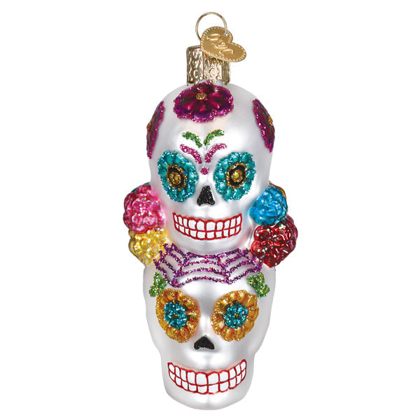 A vibrant glittery yellow sugar skull ornament with colorful floral details perfect for figural decor and dia de los muertos
