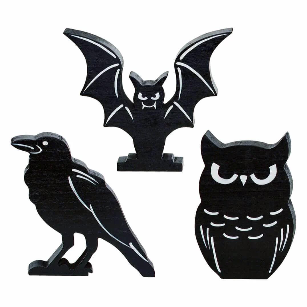 Three black silhouette figures of a bat, crow, and owl.