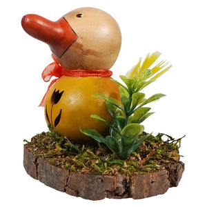 A charming hand-carved wooden dillard duck gourd with red beak and orange ribbon on mossy wood slice by meadowbrooke gourds
