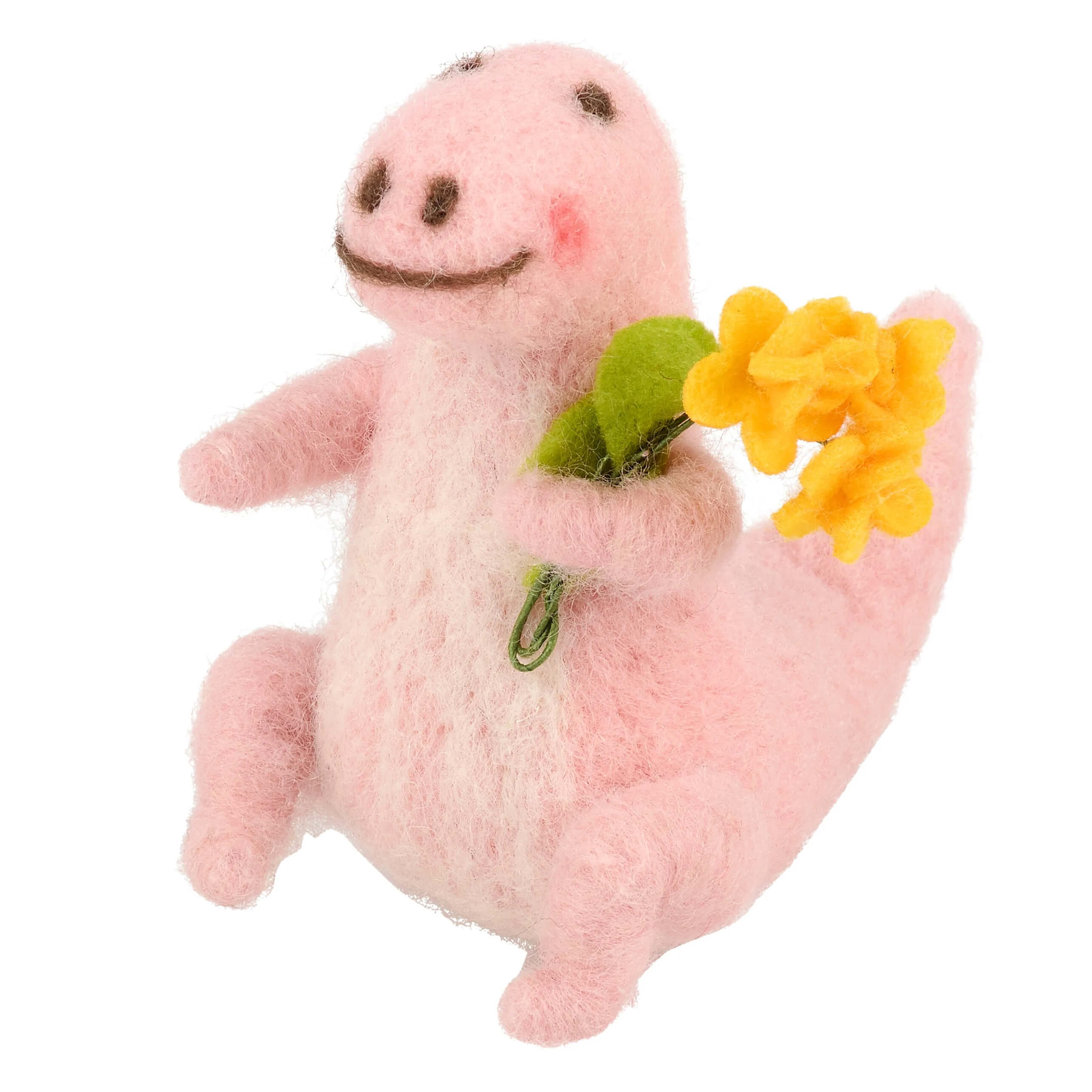 A soft pink felt dino critter holding yellow and green flowers perfect for valentine’s day figural decor