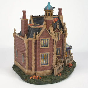 Detailed miniature victorian-style disney haunted mansion with red brick walls tan stone trim and blue domed tower for disney world fans